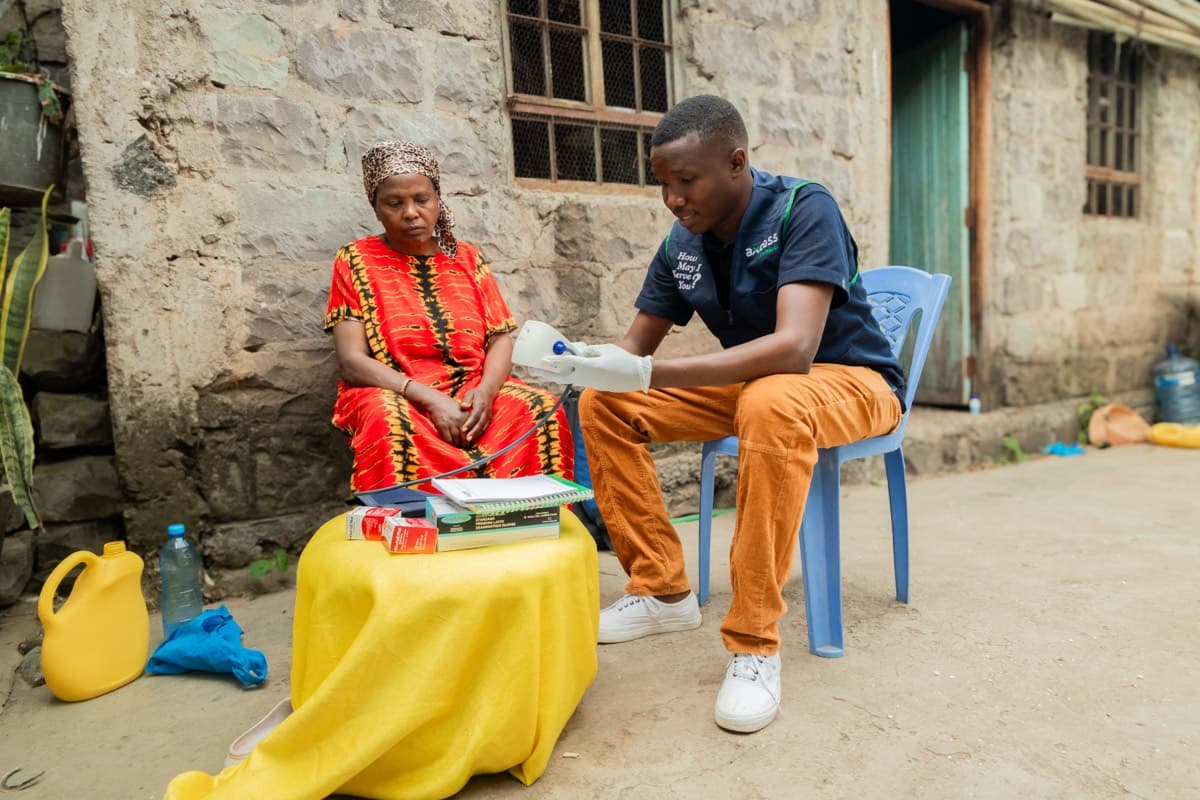 An Axcess health worker checking a patient at home